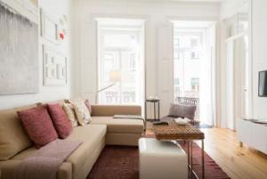 uma sala de estar com um sofá e uma mesa em Glória Apartment em Lisboa