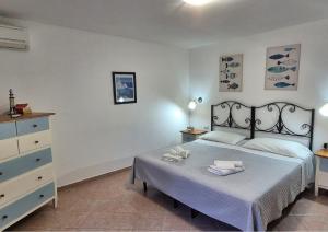 a bedroom with a bed and a dresser with towels on it at Le Palme Holidays in Palmadula +122 photos