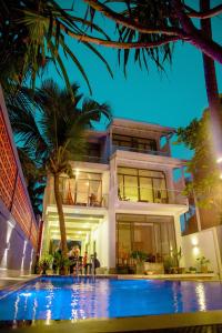 a house with a swimming pool in front of a building at Norea Sands in Bentota