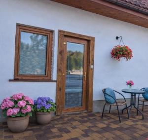 a patio with a table and chairs and flowers at Mazurski Apartament in Snopki