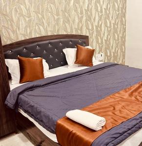a large bed with a blue comforter and pillows at Hotel Yash Residency in Ulhāsnagar