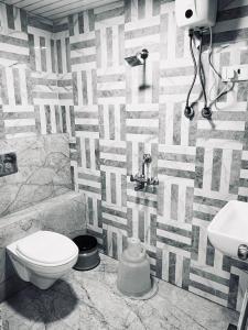 a bathroom with a toilet and a sink at Hotel Yash Residency in Ulhāsnagar