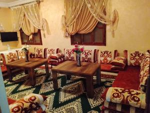 a living room with couches and tables and flowers at Sidi boulfdyl in Tiznit