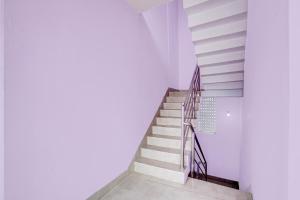 a staircase in a house with white walls at Hotel O Sri Ram Guest House in Kendrāparha