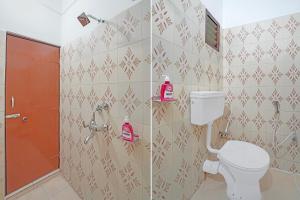 a bathroom with a toilet and a red door at Hotel O Sri Ram Guest House in Kendrāparha