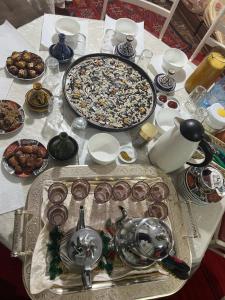 a table with a tray of food and a pizza at Gite taymate in Zaouia Ben Smine