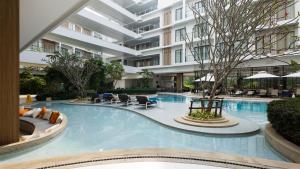 a large swimming pool in a hotel with a building at Forest View Studio at Laya Resort in Layan Beach