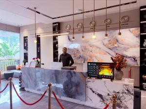 a man standing behind a counter in a lobby at Hotel Eden24 Novembre in Kinshasa