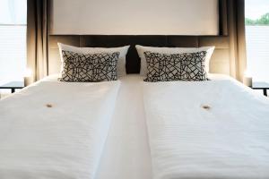 zwei Betten mit weißen Laken und Kissen in einem Schlafzimmer in der Unterkunft Hotel Apartment Ferienwohnung Meyenhof Frankenberg Eder in Frankenberg