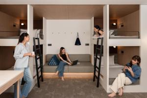 a group of people in a room with bunk beds at ASAI Bangkok Sathorn in Bangkok