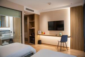 a hotel room with a bed and a television on the wall at Forest View Studio at Laya Resort in Layan Beach +45 photos