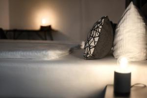 ein Bett mit zwei Kissen und einer Kerze darauf in der Unterkunft Hotel Apartment Ferienwohnung Meyenhof Frankenberg Eder in Frankenberg