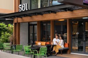 a man and woman sitting at a table outside of a building at ASAI Bangkok Sathorn in Bangkok