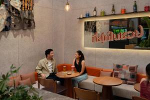 a man and woman sitting at a table in a restaurant at ASAI Bangkok Sathorn in Bangkok +30 photos