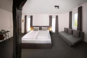 ein Schlafzimmer mit einem großen Bett und einer Couch in der Unterkunft Hotel Apartment Ferienwohnung Meyenhof Frankenberg Eder in Frankenberg