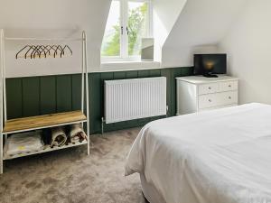 a bedroom with a white bed and a television at The Old School in Kettlewell +19 photos