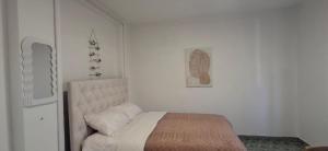 a bedroom with a bed and a painting on the wall at Apartman DMD in Bijelo Polje