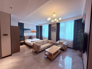 a living room with a bed and a couch and a table at Hotel Eden24 Novembre in Kinshasa