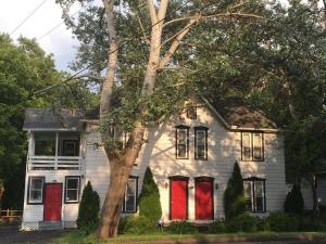 an old white house with red doors at Glass Magnolia Bed & Breakfast in Interlaken