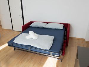 a bed with two white towels on top of it at Moderno Bilocale Con Parcheggio Privato in Piacenza