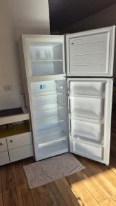a white refrigerator with its door open in a kitchen at Excelente casa com isolamento térmico, dois quarto in Itapoa