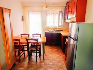 a kitchen with a table and chairs and a refrigerator at Blue Moon Apartments in Nea Michaniona