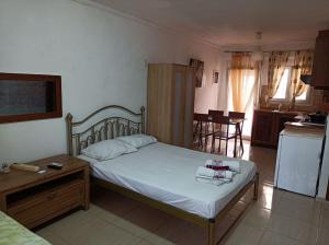 a bedroom with a bed and a table and a kitchen at Blue Moon Apartments in Nea Michaniona