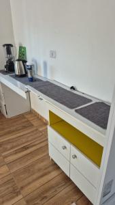 a kitchen with a white counter top and a wooden floor at Excelente casa com isolamento térmico, dois quarto in Itapoa +3 photos