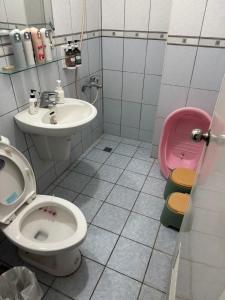 a bathroom with a toilet and a sink at Lukang Hongyu Hostel in Lukang