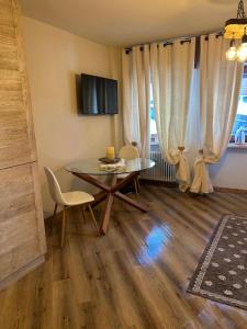 a dining room with a table and chairs and a television at Rifugio nella neve in Sestriere