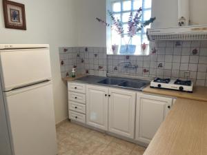 a kitchen with white cabinets and a sink at Flokos in Lygia