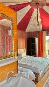 ein Schlafzimmer mit einem Bett, einem Waschbecken und einem Spiegel in der Unterkunft Camp sunset in Disah