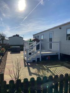a house with a porch and a white railing at 230 Unity Holiday Resort 6 Birth cosy and secure property next to all shops and entertainment passes optional in Brean