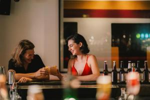 two women sitting at a bar with wine bottles at ASAI Bangkok Sathorn in Bangkok