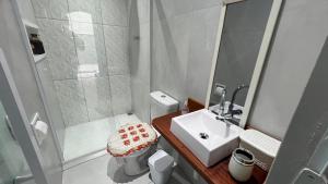 a small bathroom with a sink and a shower at hostel Bike Point Caraguatatuba in Caraguatatuba +107 photos