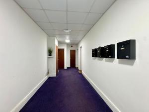 a hallway of an office with a purple carpet at West Cliff Studio - Private Garden mins from Beach in Bournemouth