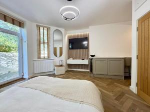 a bedroom with a bed and a flat screen tv at West Cliff Studio - Private Garden mins from Beach in Bournemouth