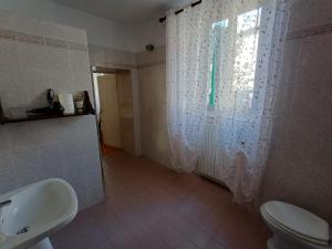 a bathroom with a sink and a toilet and a window at Bellavista in Badia Prataglia