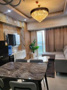 a living room with a table and a couch and a chandelier at matthew's cozzy staycation suit in Sampong