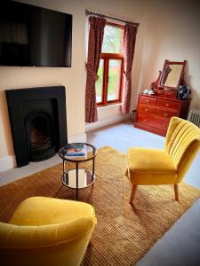a living room with a yellow chair and a fireplace at Swan Hotel Forton in Forton