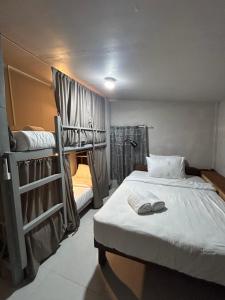 a bedroom with two bunk beds and a bathroom at Sleep Squad Hostel in El Nido