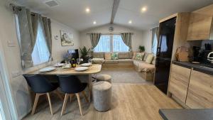a kitchen and living room with a table in a caravan at Big Boss Caravan-Camber Sands,Sleep 8, Free Wi-Fi, Netflix, Parking in Camber +20 photos