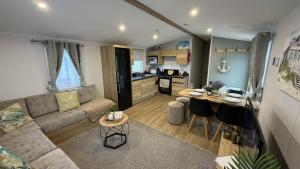 a living room with a couch and a kitchen at Big Boss Caravan-Camber Sands,Sleep 8, Free Wi-Fi, Netflix, Parking in Camber