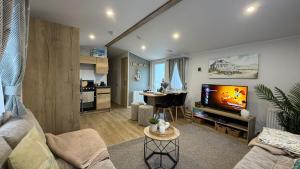 a living room with a couch and a tv at Big Boss Caravan-Camber Sands,Sleep 8, Free Wi-Fi, Netflix, Parking in Camber