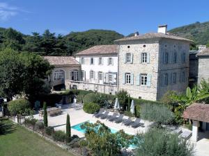 a large stone building with a pool in front of it at Château Meilhen in Les Mages
