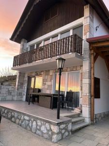 a house with a balcony and a table on a patio at Duna Panoráma Vendégház in Mohács