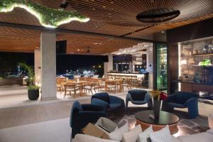a restaurant with tables and chairs and a bar at Hotel Indigo - Galapagos by IHG in Puerto Baquerizo Moreno