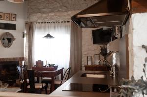 a kitchen and dining room with a table and a stove at Casa Rural Concejos in San Román de Cameros