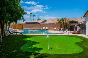 a yard with a putting green and a pool at Desert Escape - Private Pool - Spa in Indio