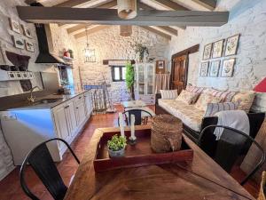 a kitchen and living room with a couch and a table at Casa Rural Concejos in San Román de Cameros